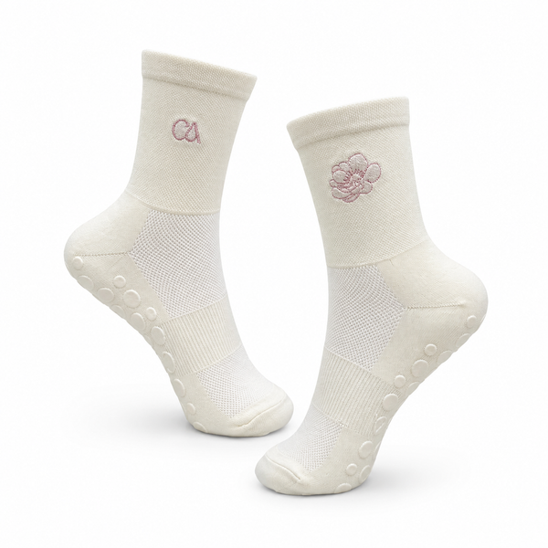 Cama reformer sokker i krem med rosa Cama-logo og antiskli-grep, til pilates og yoga
